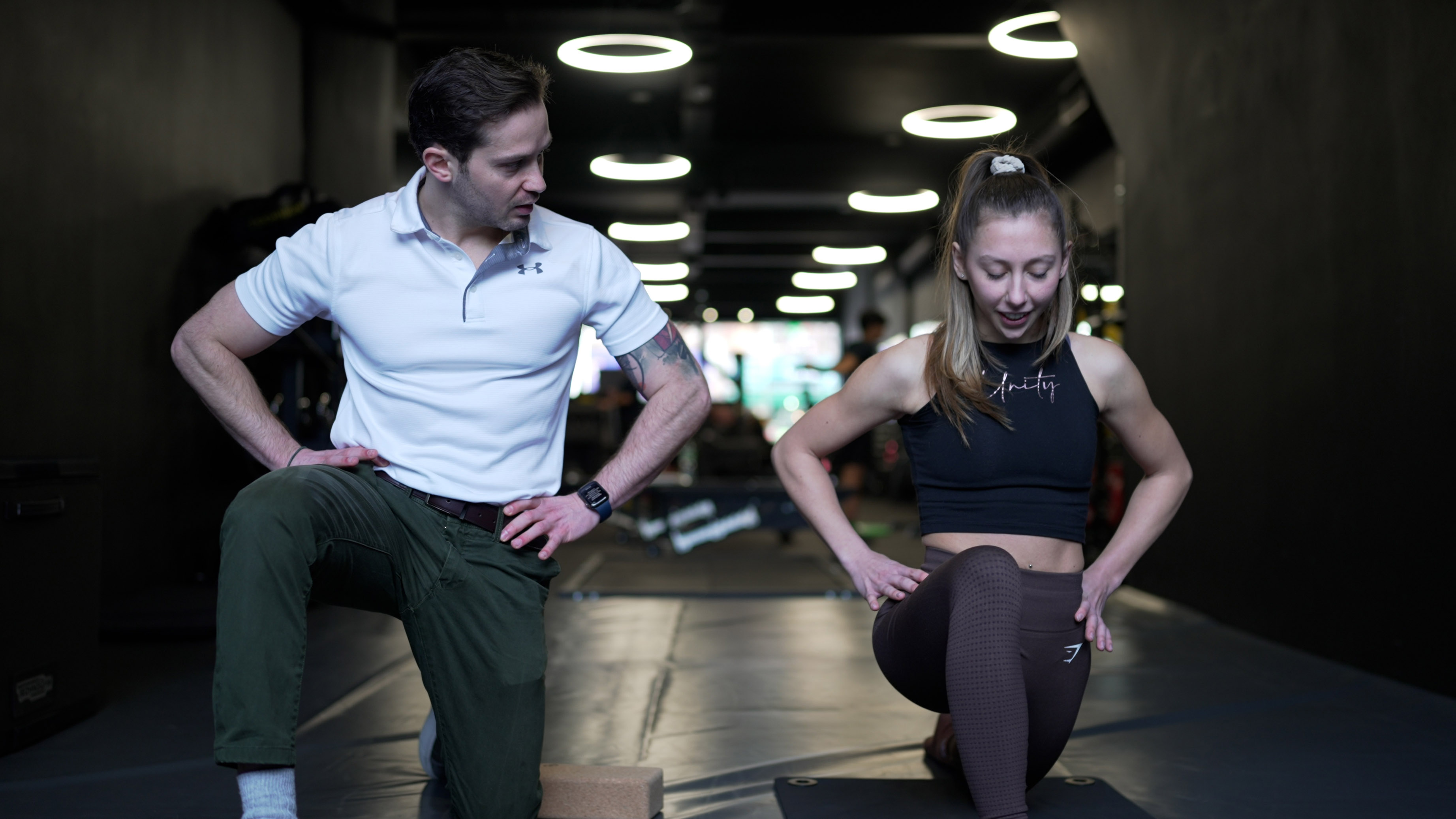 Alex Barmpas coaching a client through a reverse lunge exercise