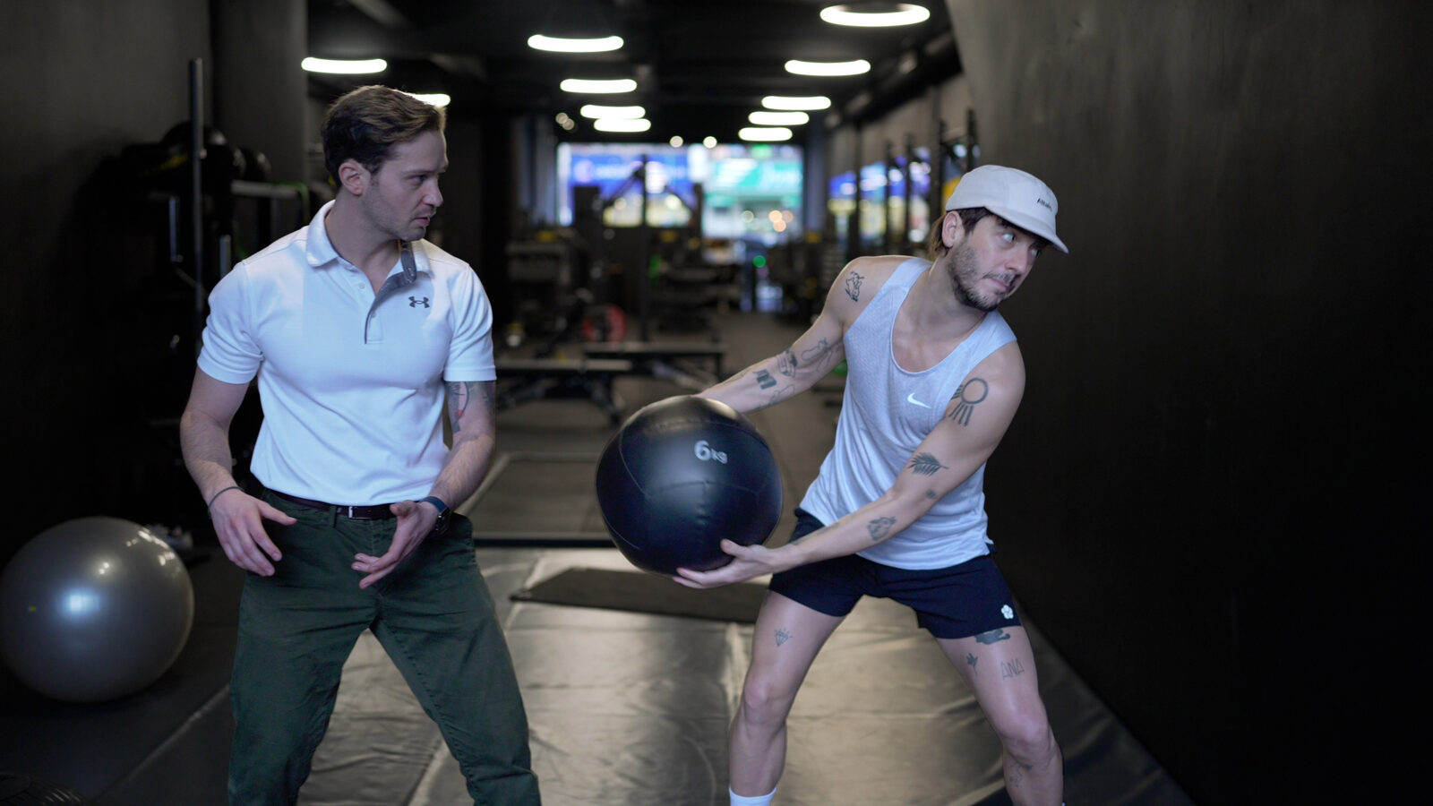 Alex Barmpas coaching a client through a medicine ball training exercise